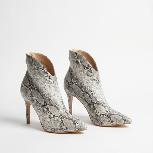 Pair of snake print high-heeled ankle boots on a light gray background