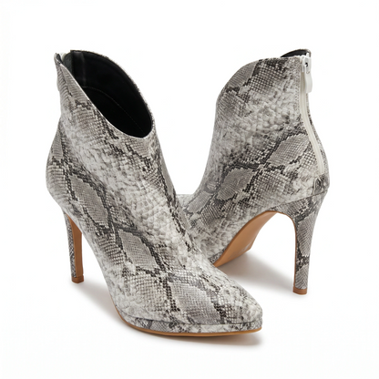 Pair of snake print high-heeled ankle boots on a white background