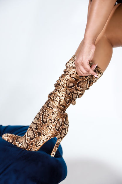 Tiosebon Snake Boots featuring snake print high heel boots with pointed toes and slouchy knee-high style